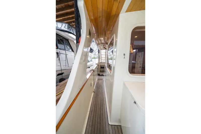 Slide: The Image of Side deck view of 1973 American Marine Alaskan 53 yacht with wooden ceiling and white exterior. - 44