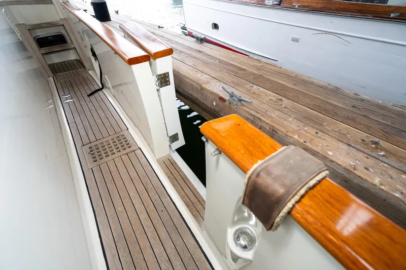 Slide: The Image of 1973 American Marine Alaskan 53 yacht deck with wooden finish and dock view. - 46