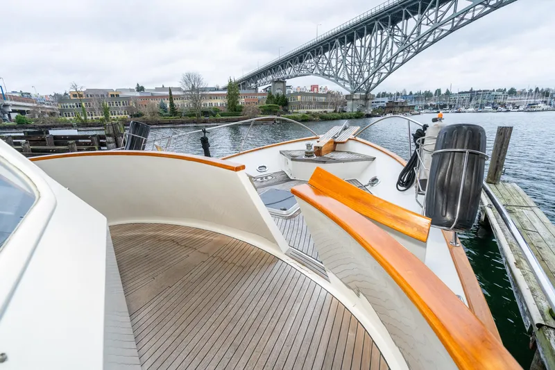 Slide: The Image of 1973 American Marine Alaskan 53 yacht docked near a bridge, showcasing elegant wooden deck. - 50
