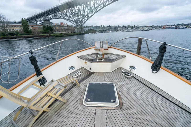 Slide: The Image of Deck view of 1973 American Marine Alaskan 53 yacht under a bridge, with scenic waterfront. - 51