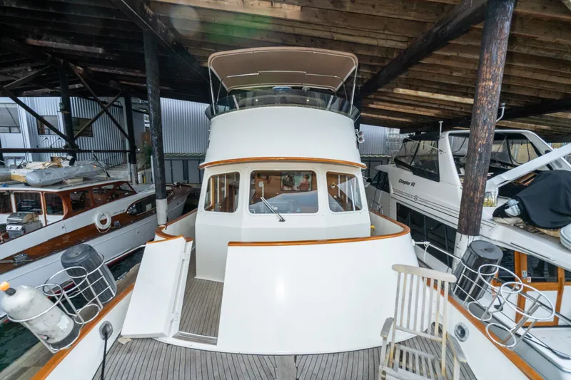 Slide: The Image of 1973 American Marine Alaskan 53 yacht docked under a wooden shelter. - 53