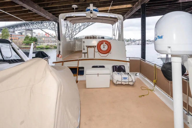 Slide: The Image of 1973 American Marine Alaskan 53 yacht docked under a bridge, featuring deck equipment. - 58