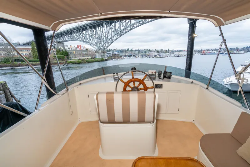 Slide: The Image of 1973 American Marine Alaskan 53 yacht helm with bridge view, serene waterfront setting. - 63