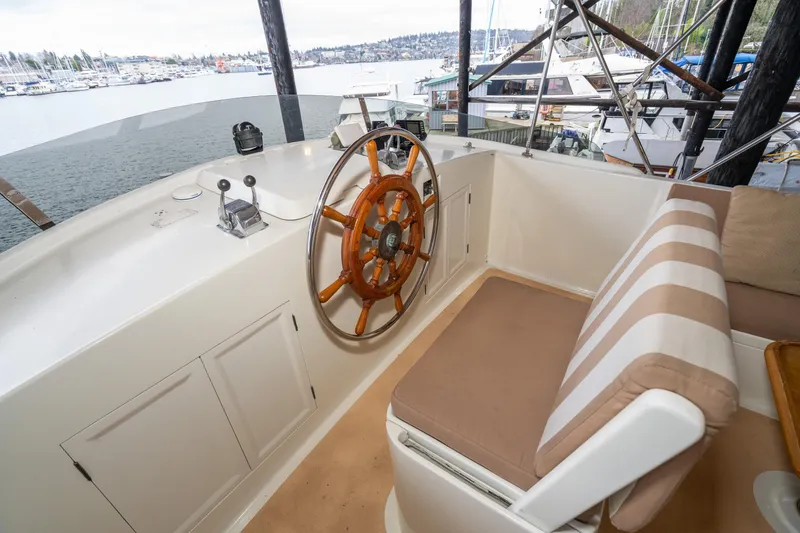 Slide: The Image of 1973 American Marine Alaskan 53 yacht helm with wooden wheel and striped seating. - 65