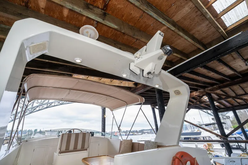 Slide: The Image of 1973 American Marine Alaskan 53 yacht under wooden dock, featuring seating and canopy. - 70