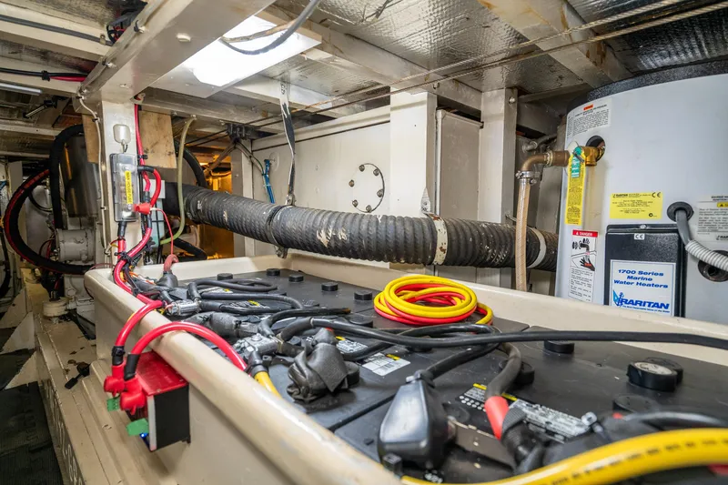 Slide: The Image of Engine room of a 1973 American Marine Alaskan 53 yacht, featuring batteries and marine equipment. - 74