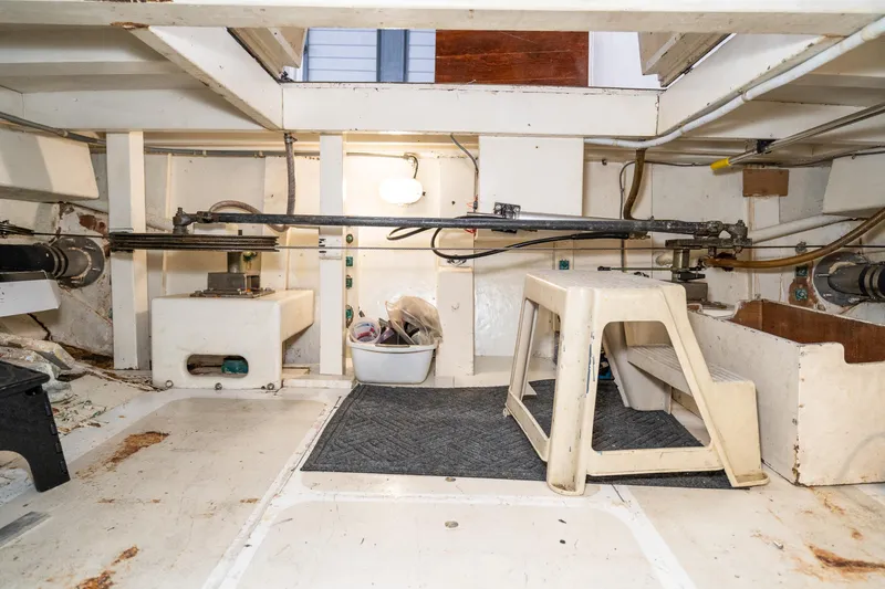 Slide: The Image of Engine room of a 1973 American Marine Alaskan 53 yacht, featuring mechanical components and storage. - 81