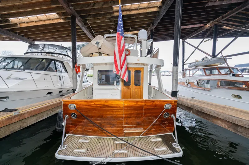 Slide: The Image of 1973 American Marine Alaskan 53 yacht docked under a wooden shelter. - 82