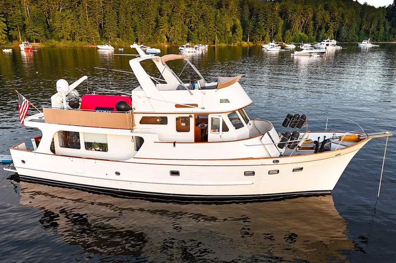 Slide: The Image of 1973 American Marine Alaskan 53 yacht on serene lake with forest backdrop. - 84