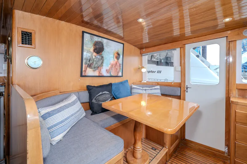 Slide: The Image of Interior of 1973 American Marine Alaskan 53 yacht with wooden dining area and cozy seating. - 9
