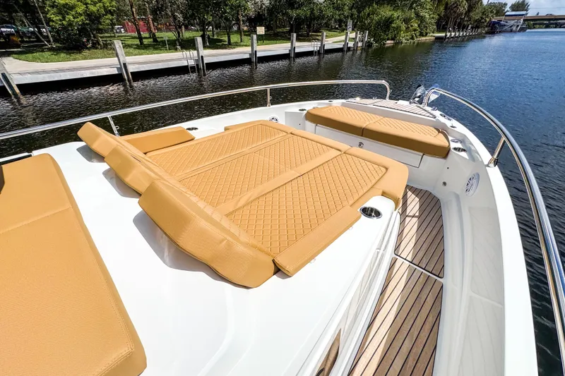 Slide: The Image of Luxurious 2025 Wellcraft 38 Explorer boat with tan cushioned seating on deck by the water. - 40