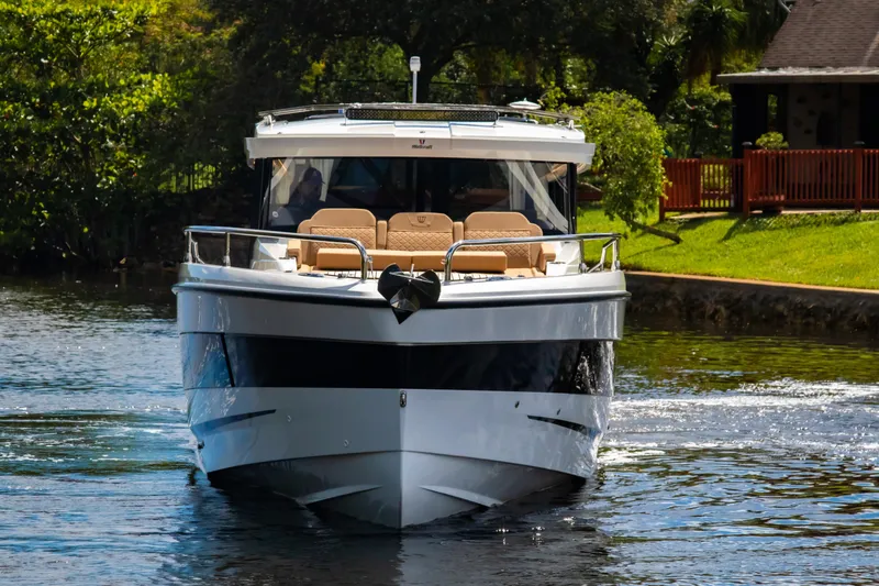 Slide: The Image of 2025 Wellcraft 38 Explorer boat cruising on a serene river near lush greenery. - 6