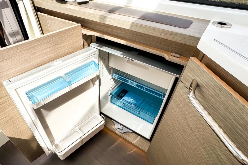 Slide: The Image of Compact refrigerator in 2025 Wellcraft 38 Explorer boat kitchen, featuring modern wood cabinetry. - 25
