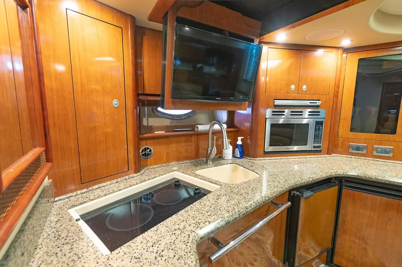 Slide: The Image of Luxurious 2005 Sea Ray 420 Sundancer yacht kitchen with modern appliances and elegant wood cabinetry. - 19