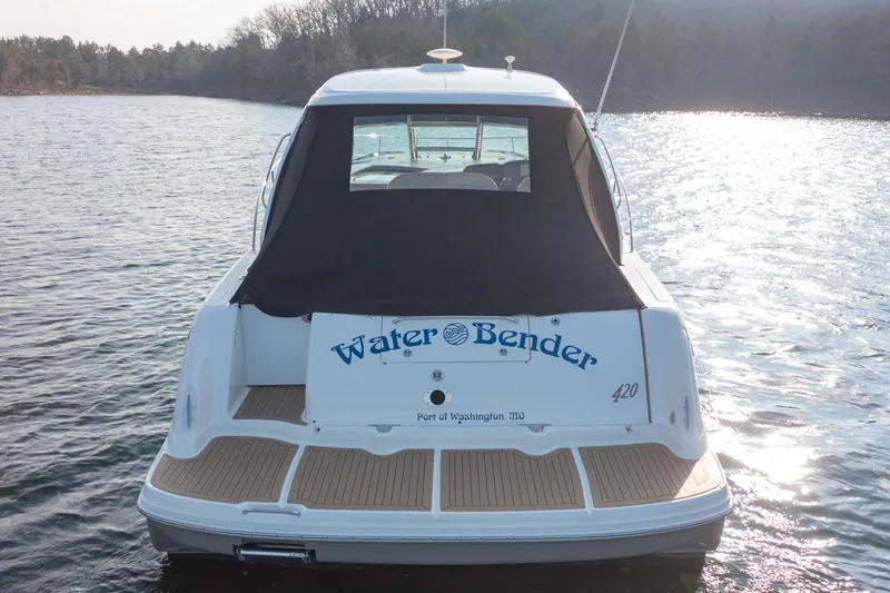 Slide: The Image of 2005 Sea Ray 420 Sundancer boat named "Water Bender" on a calm lake. - 6