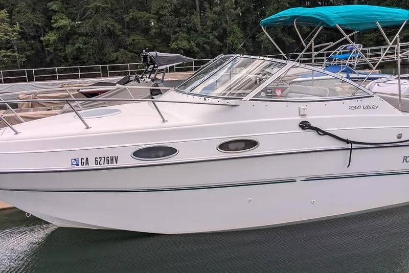 The Image of 1997 Four Winns 238 Vista boat docked, featuring sleek design and white exterior. - 0