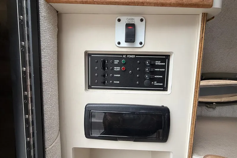 Slide: The Image of 1997 Four Winns 238 Vista cabin control panel with AC power switches and cabin lights. - 10