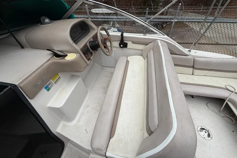Slide: The Image of 1997 Four Winns 238 Vista boat interior with steering wheel and seating area. - 11