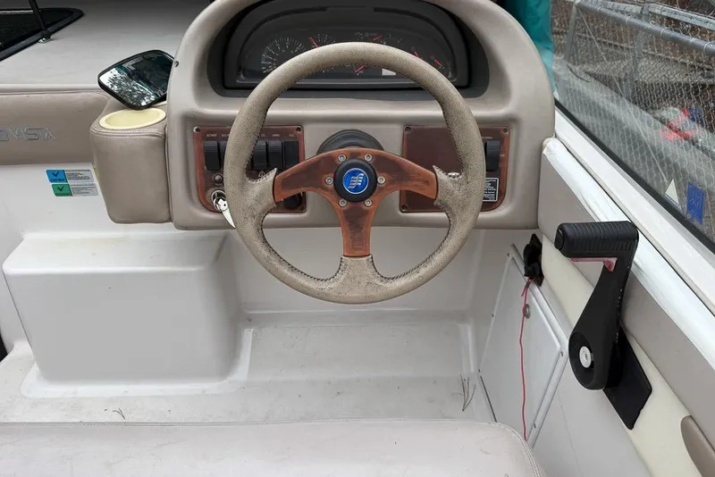 Slide: The Image of Steering wheel of a 1997 Four Winns 238 Vista boat, featuring a classic dashboard design. - 13