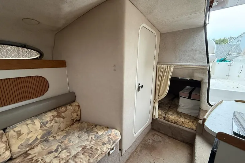 Slide: The Image of 1997 Four Winns 238 Vista cabin interior with seating, storage, and compact design. - 5