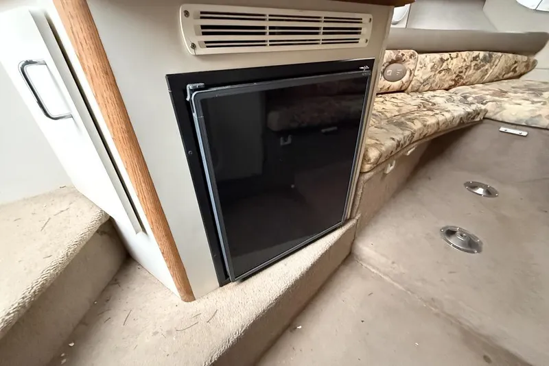 Slide: The Image of Interior of 1997 Four Winns 238 Vista boat with mini fridge and seating area. - 7