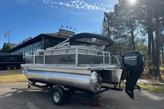 Slide: The Image of 2026 Sun Tracker Bass Buggy 16 XL Select pontoon boat with Mercury engine on trailer. - 4