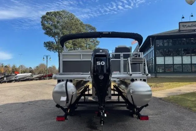 Slide: The Image of 2026 Sun Tracker Bass Buggy 16 XL Select pontoon boat with 50 HP engine, parked outdoors. - 5