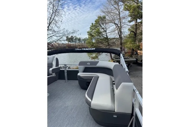 Slide: The Image of 2026 Sun Tracker Bass Buggy 16 XL Select pontoon boat with seating, near a scenic lake. - 8