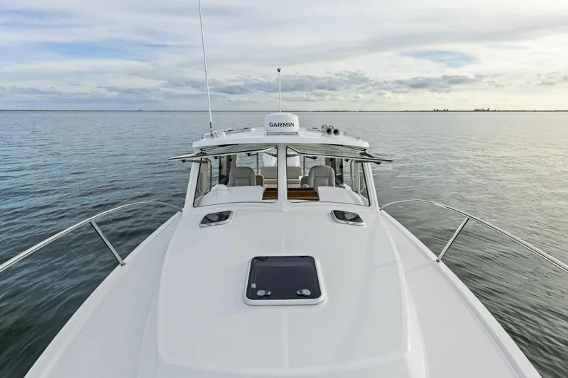 Slide: The Image of 2025 MJM 35 boat on calm water, featuring sleek design and Garmin equipment. - 35