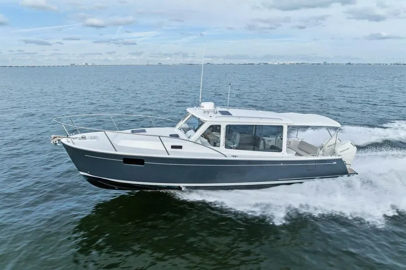 Slide: The Image of 2025 MJM 35 boat cruising on open water under a cloudy sky. - 49