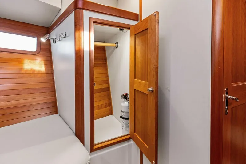 Slide: The Image of 2025 MJM 35 yacht interior with wooden cabinetry and storage compartment. - 9