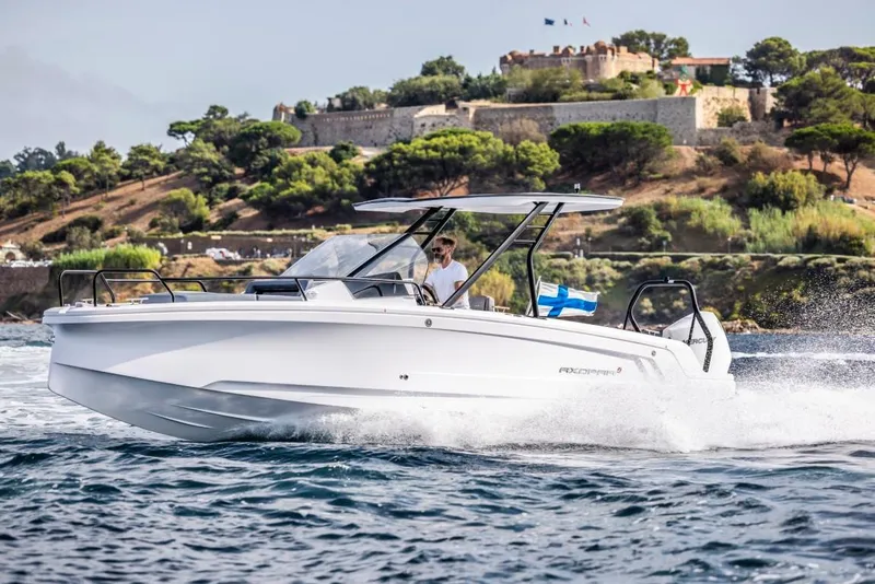 Slide: The Image of 2024 Axopar 25 Cross Top boat cruising near scenic coastline. - 10