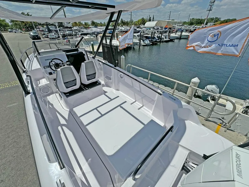 Slide: The Image of 2024 Axopar 25 Cross Top boat docked at marina, showcasing sleek design and spacious seating. - 4