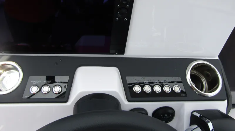 Slide: The Image of Control panel of 2024 Axopar 25 Cross Top boat with buttons and cup holders. - 16