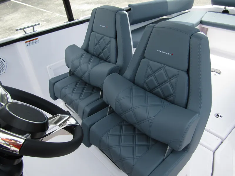 Slide: The Image of 2024 Axopar 25 Cross Top boat interior with luxurious, diamond-stitched seats and modern steering wheel. - 19