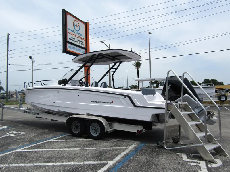 Slide: The Image of 2024 Axopar 25 Cross Top boat on a trailer at a dealership. - 2