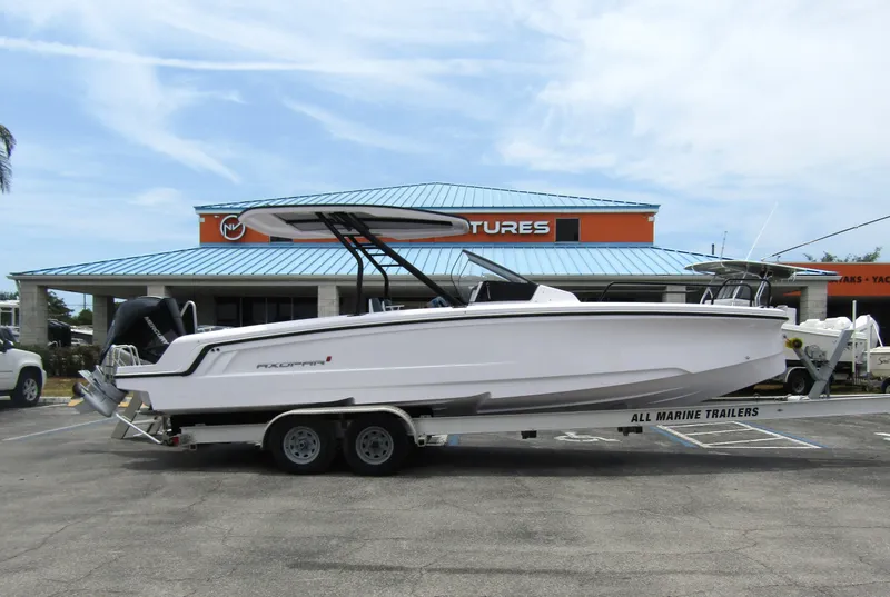 Slide: The Image of 2024 Axopar 25 Cross Top boat on a trailer in front of a dealership. - 5