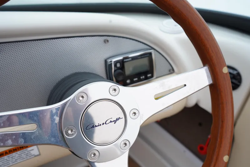 Slide: The Image of Steering wheel of 2015 Chris-Craft Lancer 20 boat with wood and metal design. - 15