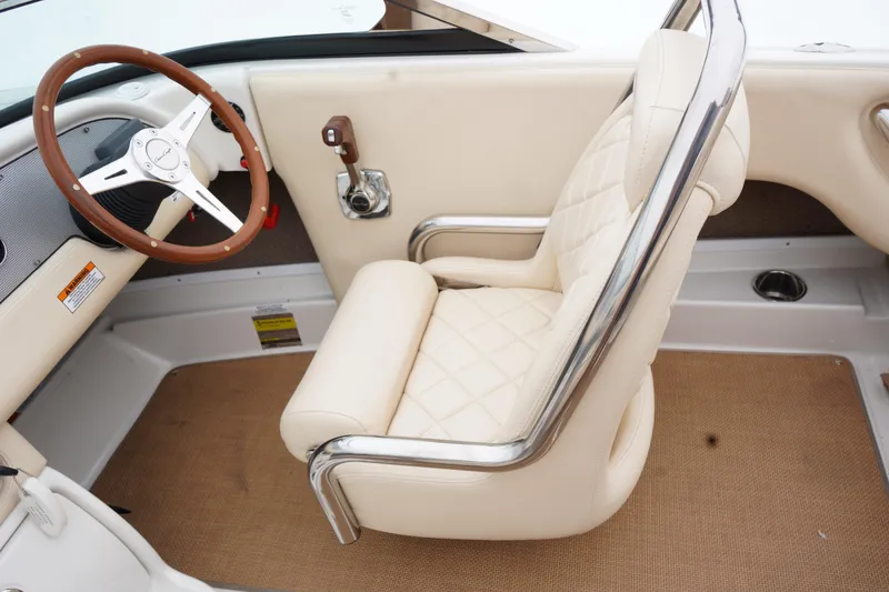 Slide: The Image of 2015 Chris-Craft Lancer 20 interior with beige leather seat and wooden steering wheel. - 21