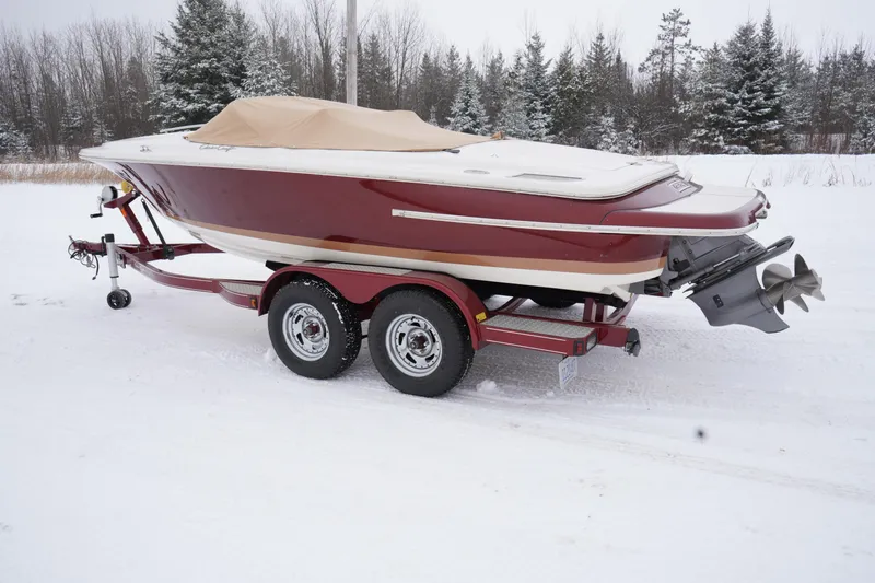 Slide: The Image of 2015 Chris-Craft Lancer 20 boat on trailer in snowy landscape. - 3