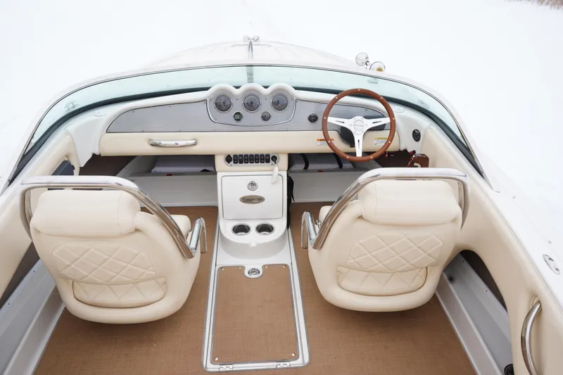 Slide: The Image of 2015 Chris-Craft Lancer 20 boat interior with beige leather seats and wooden steering wheel. - 31