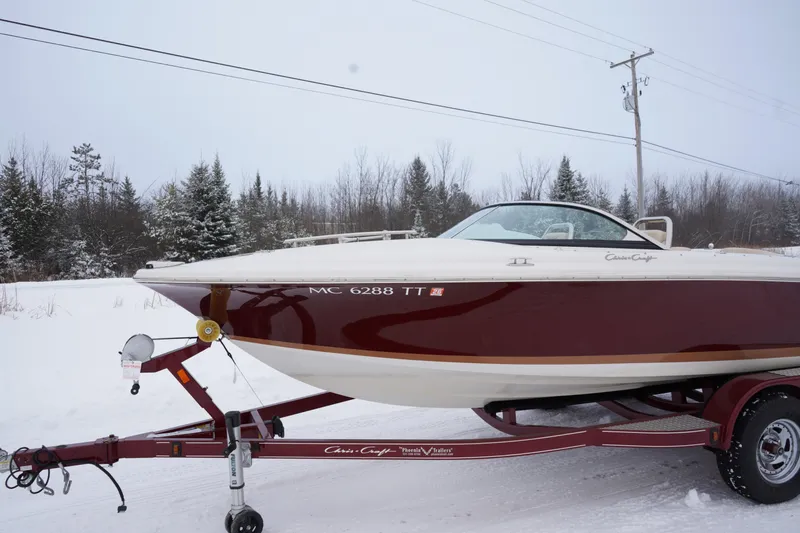 Slide: The Image of 2015 Chris-Craft Lancer 20 boat on trailer in snowy landscape. - 35