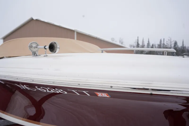 Slide: The Image of 2015 Chris-Craft Lancer 20 boat with registration number, parked near a building in winter. - 6