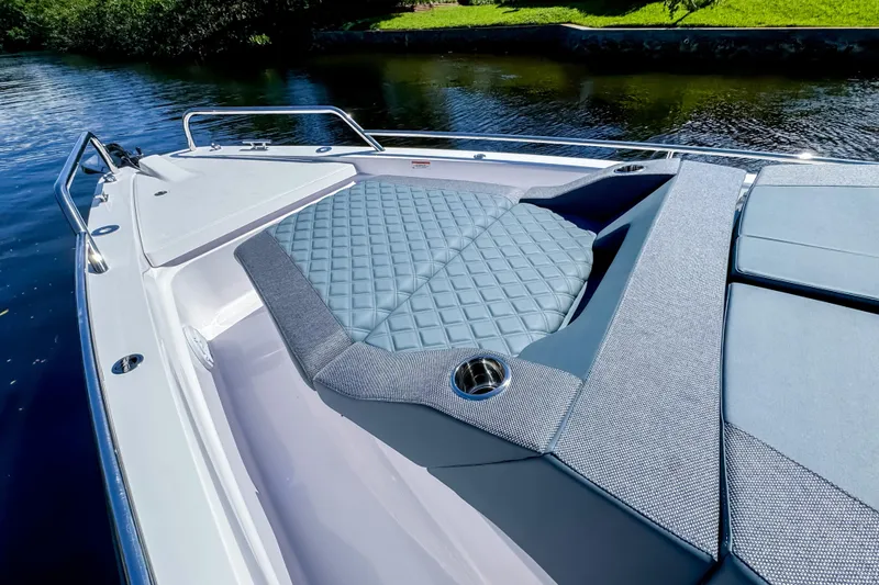 Slide: The Image of 2024 Axopar 37 Sun Top boat with cushioned deck area by the water. - 26