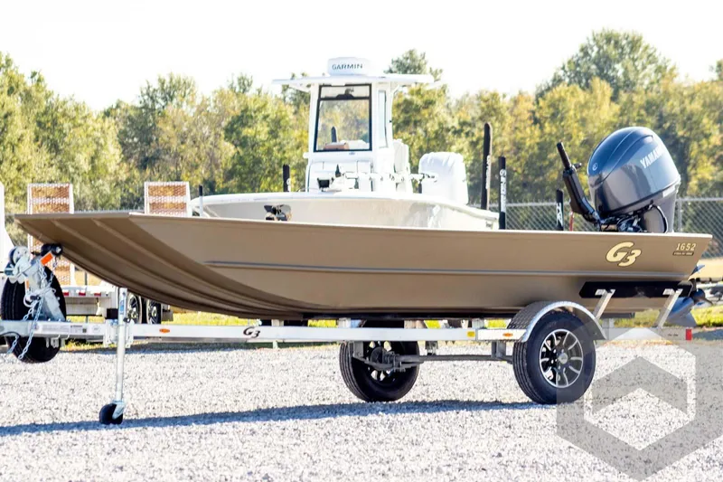 The Image of 2026 G3 Gator Tough 1652 VBW boat on trailer, outdoors with trees in background. - 1