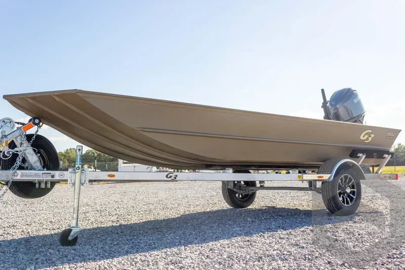 Slide: The Image of 2026 G3 Gator Tough 1652 VBW boat on trailer, gravel lot background. - 12