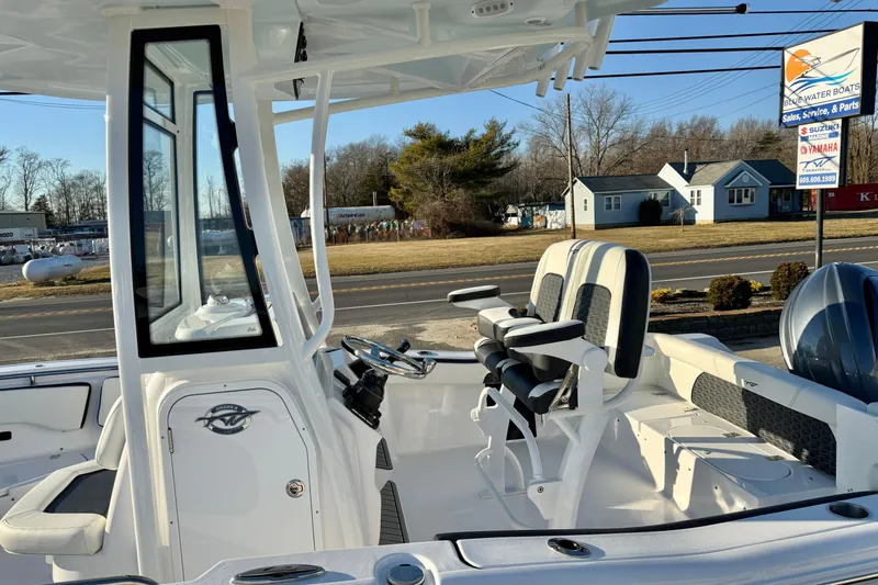 Slide: The Image of 2026 Tidewater 220 LXF boat interior with seating and console, parked near dealership. - 11