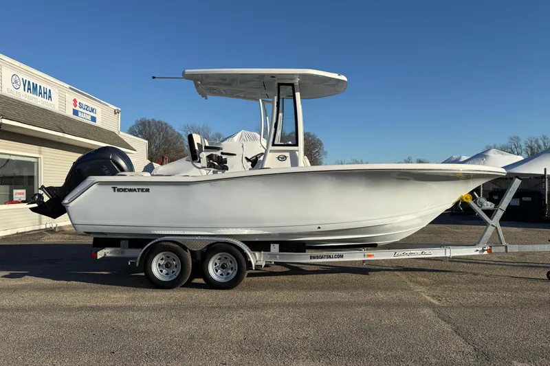 Slide: The Image of 2026 Tidewater 220 LXF boat on trailer at dealership, clear sky background. - 18