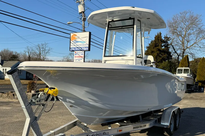 Slide: The Image of 2026 Tidewater 220 LXF boat on trailer at dealership, clear sky background. - 22