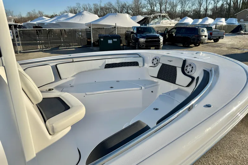 Slide: The Image of 2026 Tidewater 220 LXF boat interior with seating and speakers, parked outdoors. - 7